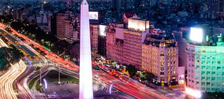 Vista panorâmica da Avenida 9 de julho à noite, no centro de Buenos Aires. Obelisco e luzes da cidade na hora do rush.
