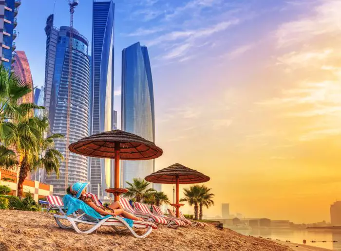 Pessoa deitada em uma espreguiçadeira pegando sol em uma praia de Dubai