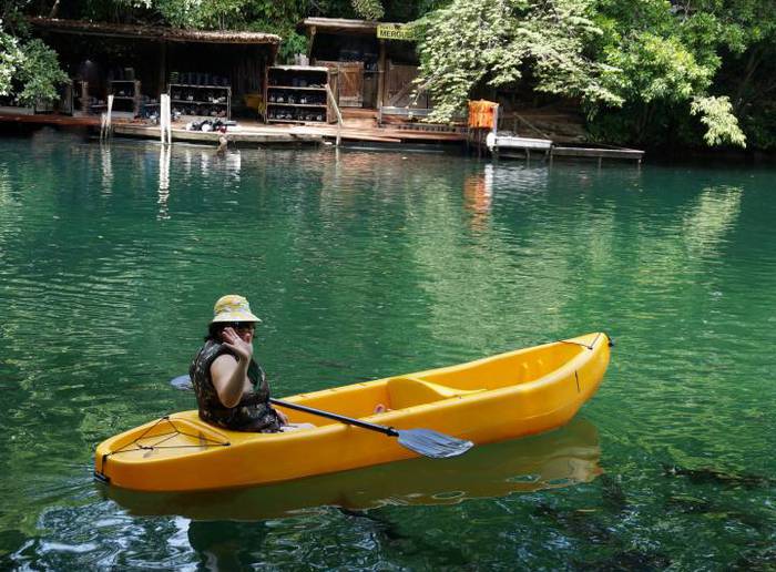 Turista passeando de canoa nas águas termais e cristalinas do Lago Corumbá.