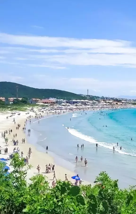 Panorama aéreo da extensa linha costeira de Cabo Frio, Rio de Janeiro, revelando praias de areia branca banhadas por águas azul-turquesa. Uma visão paradisíaca para quem busca pacotes de viagens com belas paisagens.