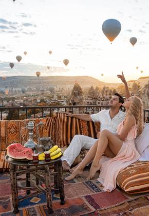 Lindo casal olhando para os balões no céu de Capadócia, na Turquia