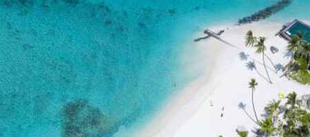 Mar azul turquesa, areia branca e hotel com piscina pé na areia