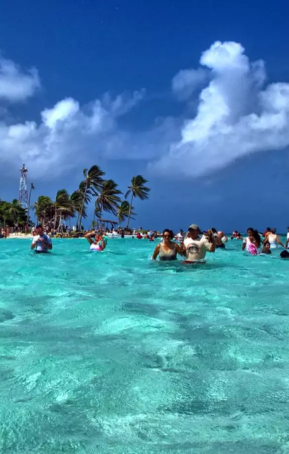 Cenário paradisíaco de San Andrés, com areias brancas, mar azul-turquesa e uma vegetação exuberante.