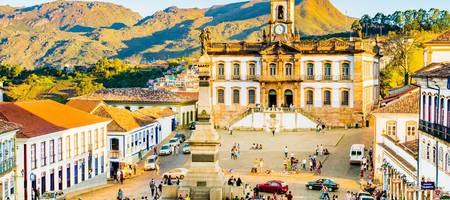 Visite o histórico centro de Ouro Preto com suas icônicas arquiteturas coloniais, movimentada praça central e a imponente paisagem montanhosa.