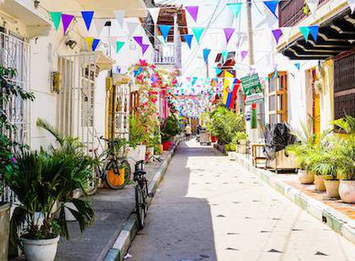 Rua em Cartagena com bandeirinhas coloridas penduradas entre as casas