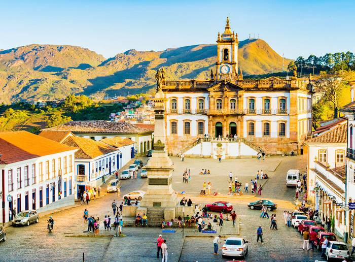 Visite o histórico centro de Ouro Preto com suas icônicas arquiteturas coloniais, movimentada praça central e a imponente paisagem montanhosa.