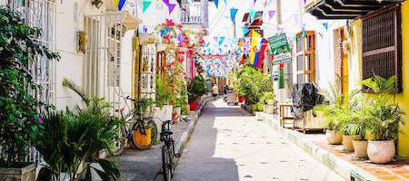 Rua em Cartagena com bandeirinhas coloridas penduradas entre as casas