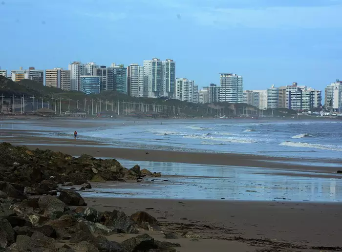Visão panorâmica da praia de São Luís no fim da tarde com turistas se banhando.