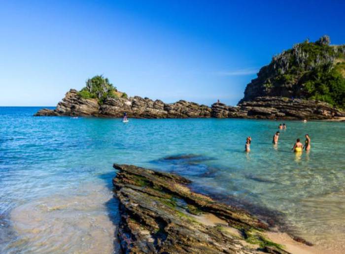 Pessoas se banhando na paradisíaca Praia da Ferradurinha.